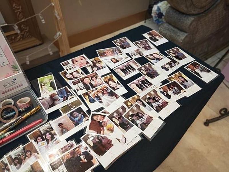 印卡讚婚宴現場的拍貼成品展示桌,桌上鋪滿列印出的拍立得風格照片